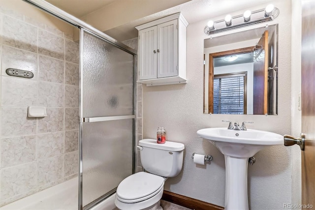 bathroom featuring walk in shower, sink, and toilet