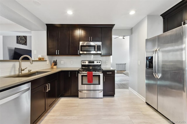 kitchen featuring dark brown cabinetry, decorative backsplash, sink, and stainless steel appliances