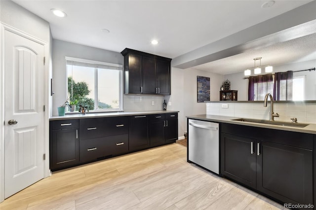 kitchen with tasteful backsplash, sink, light hardwood / wood-style flooring, dishwasher, and hanging light fixtures