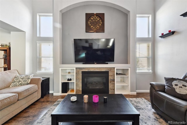 living room featuring dark hardwood / wood-style flooring, a fireplace, and built in features