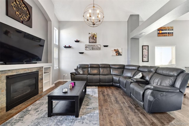 living room featuring hardwood / wood-style flooring, a fireplace, and a notable chandelier