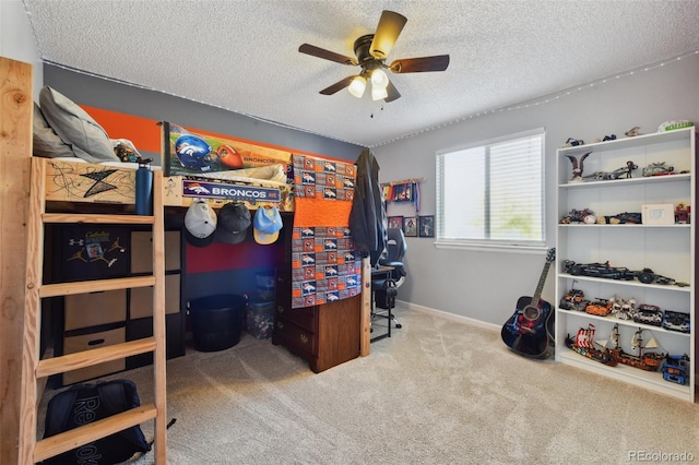 bedroom featuring ceiling fan, a textured ceiling, and light carpet