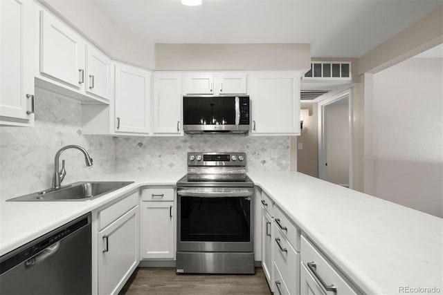 kitchen featuring white cabinetry, stainless steel appliances, sink, and decorative backsplash