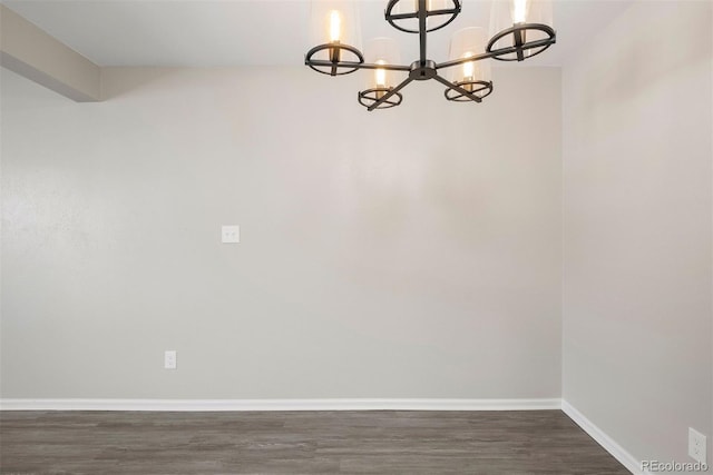 unfurnished dining area with an inviting chandelier and dark wood-type flooring