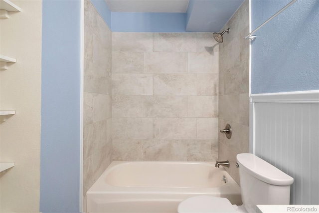 bathroom featuring tiled shower / bath and toilet