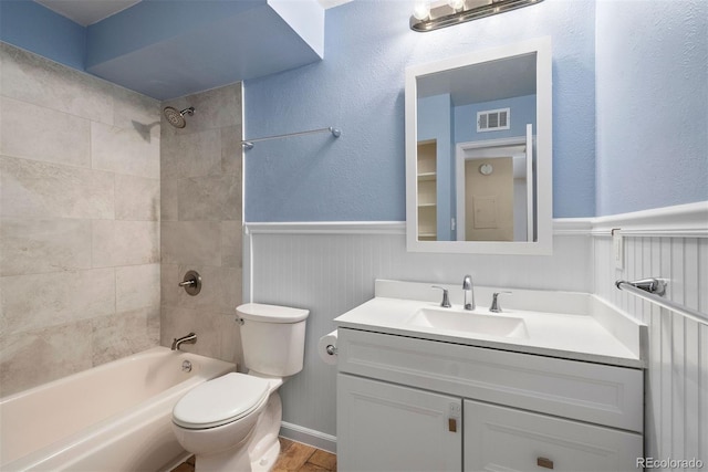 3663 S Sheridan Blvd Unit 2, Denver, CO 80235 - full bathroom featuring toilet, vanity, tub / shower combination, and a wainscoted wall