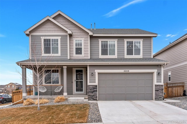 craftsman-style home with covered porch, a front yard, and a garage