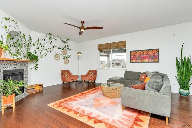 living room with a tile fireplace, hardwood / wood-style floors, and ceiling fan