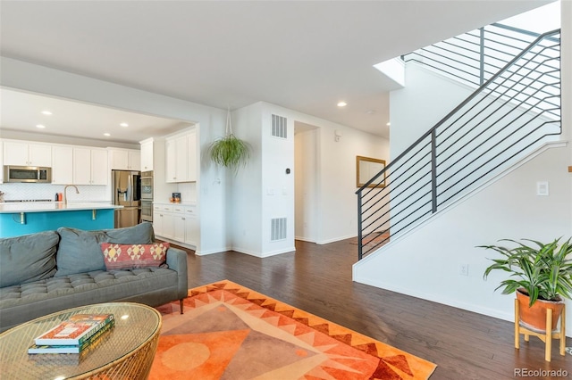 living room with sink and dark hardwood / wood-style floors