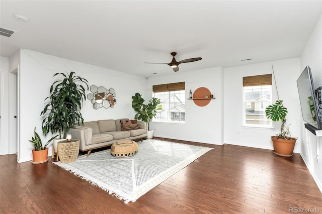 living room featuring ceiling fan and dark wood-type flooring