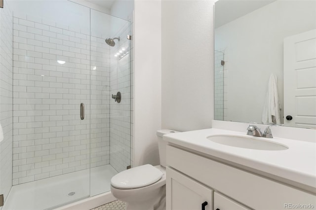 bathroom with toilet, vanity, and an enclosed shower