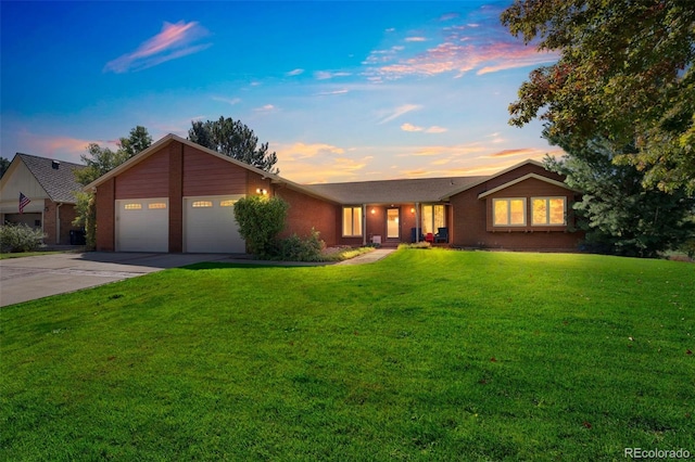 ranch-style home featuring a garage and a yard