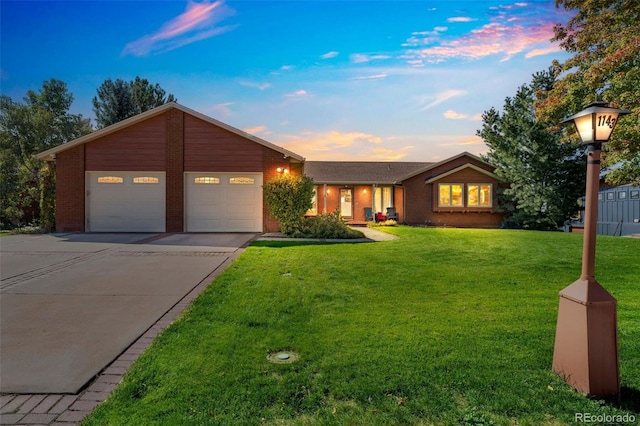 ranch-style home featuring a garage and a yard