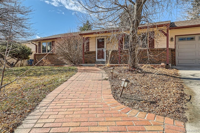ranch-style home featuring brick siding, an attached garage, and driveway