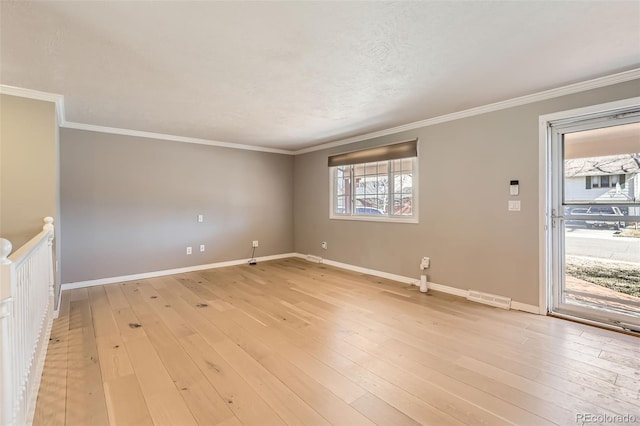 unfurnished living room featuring light wood-type flooring, visible vents, baseboards, and crown molding