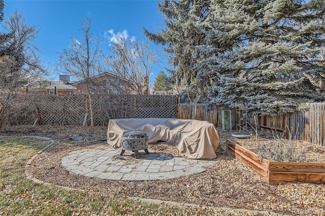 view of yard featuring an outdoor fire pit, a patio, a fenced backyard, and a vegetable garden