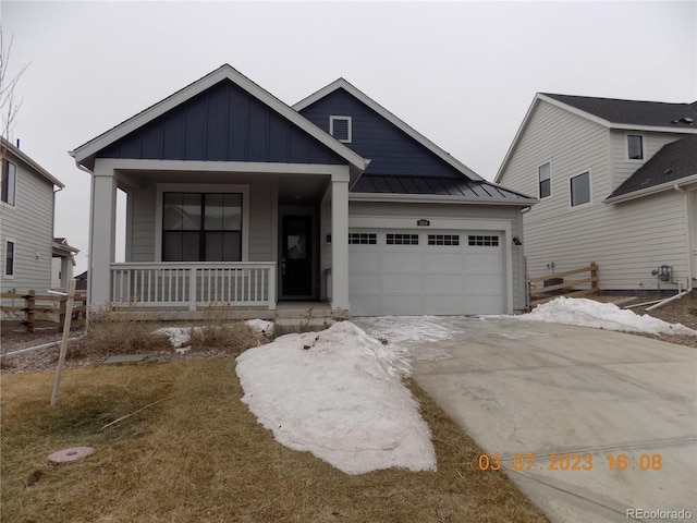 view of front of home with a standing seam roof, covered porch, board and batten siding, concrete driveway, and an attached garage