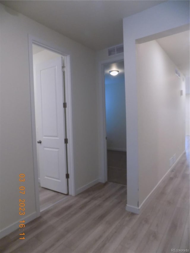 empty room featuring visible vents, baseboards, and light wood-style floors