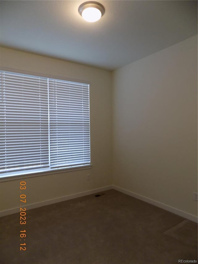 empty room featuring baseboards and carpet floors