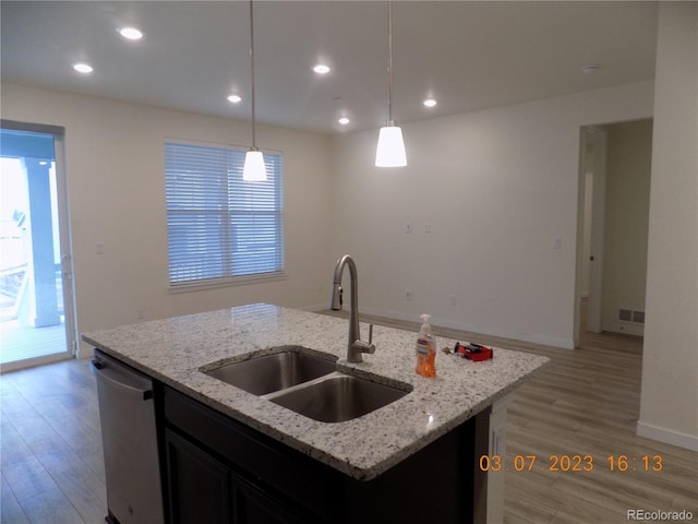 kitchen with a sink, dishwasher, recessed lighting, light wood-style flooring, and a kitchen island with sink