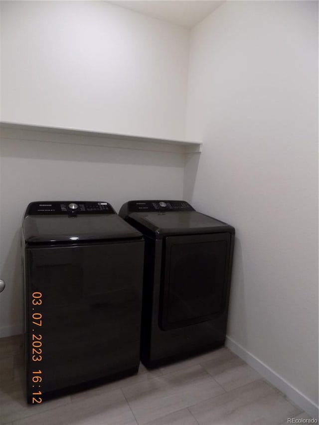 laundry area featuring laundry area, baseboards, and separate washer and dryer