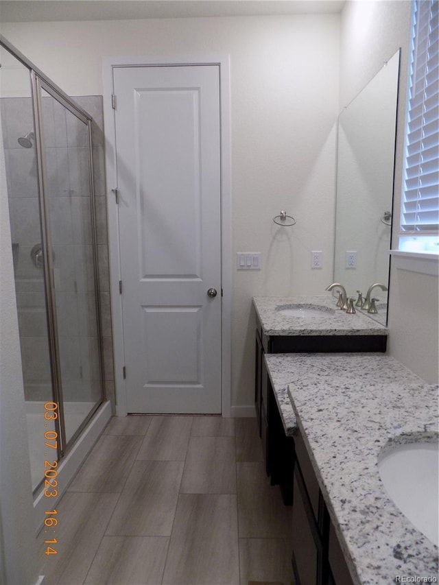 bathroom with a stall shower, vanity, and wood finish floors