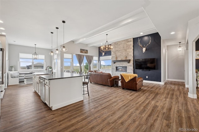 19751 Good Life Vw, Calhan, CO 80808 - kitchen featuring a chandelier, dark countertops, dark wood finished floors, an island with sink, and white cabinetry