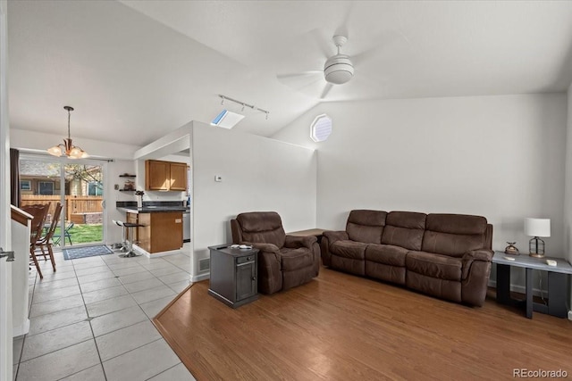11296 Daisy Ct, Firestone, CO 80504 - living area featuring vaulted ceiling, rail lighting, a ceiling fan, light tile patterned floors, and a chandelier