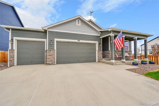 view of front of home with concrete driveway, an attached garage, and stone siding