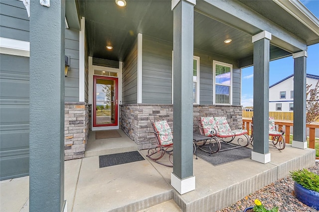 doorway to property with covered porch and stone siding