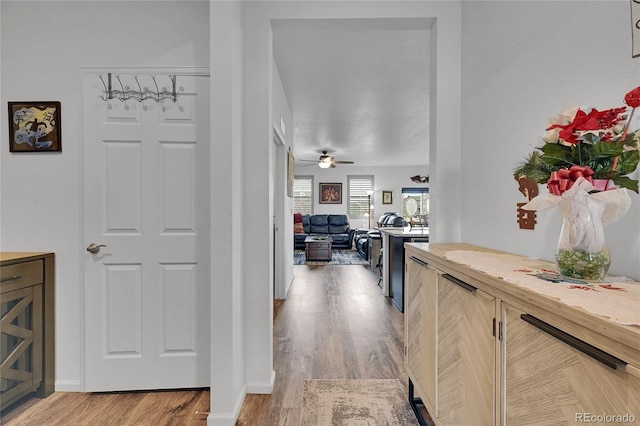 hallway featuring baseboards and light wood-style flooring