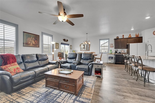 living area with plenty of natural light, recessed lighting, ceiling fan with notable chandelier, and wood finished floors