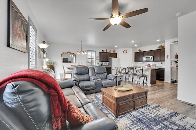 living area featuring recessed lighting, visible vents, light wood finished floors, and ceiling fan with notable chandelier