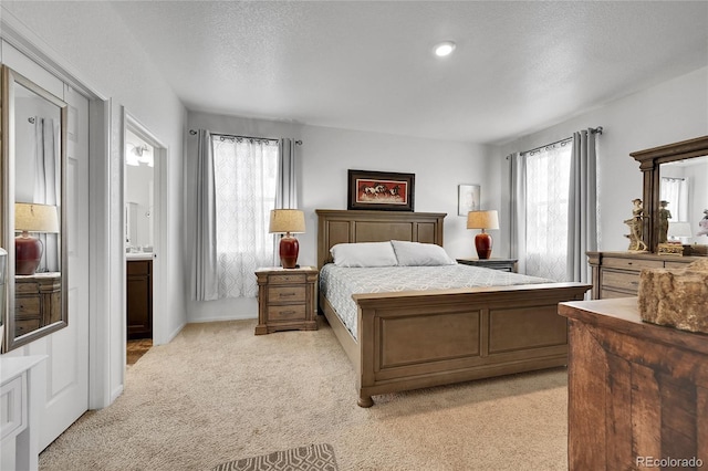 bedroom with multiple windows, light carpet, and a textured ceiling