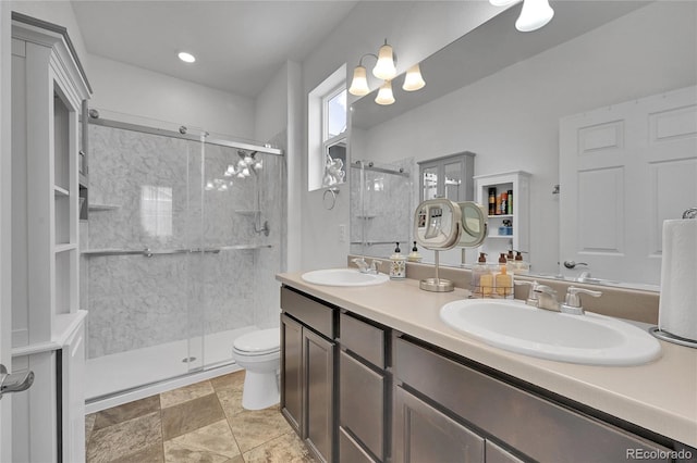 bathroom featuring a sink, a shower stall, and double vanity