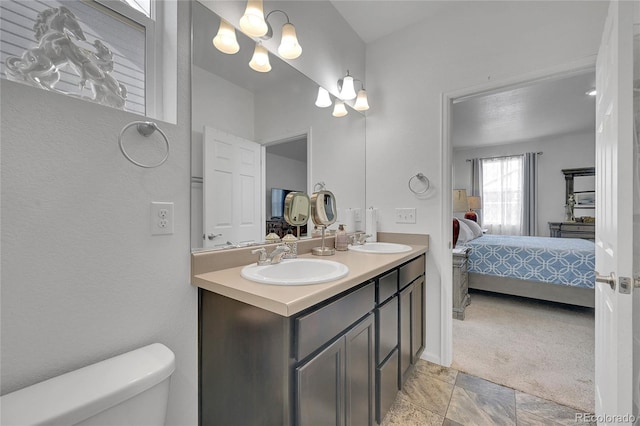 bathroom featuring a sink, ensuite bathroom, toilet, and double vanity