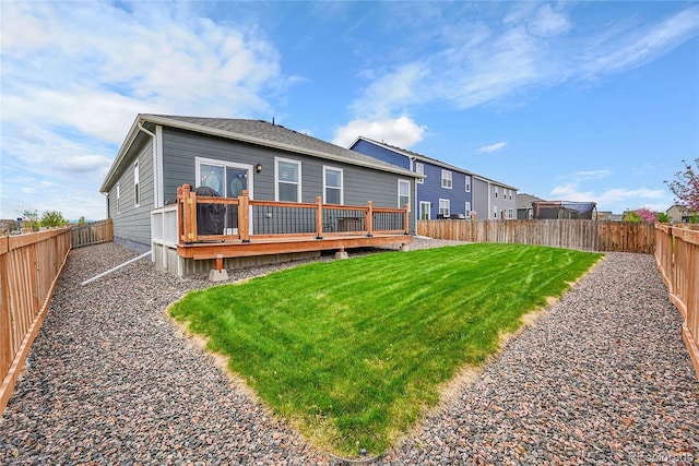 back of property featuring a lawn, a fenced backyard, and a wooden deck