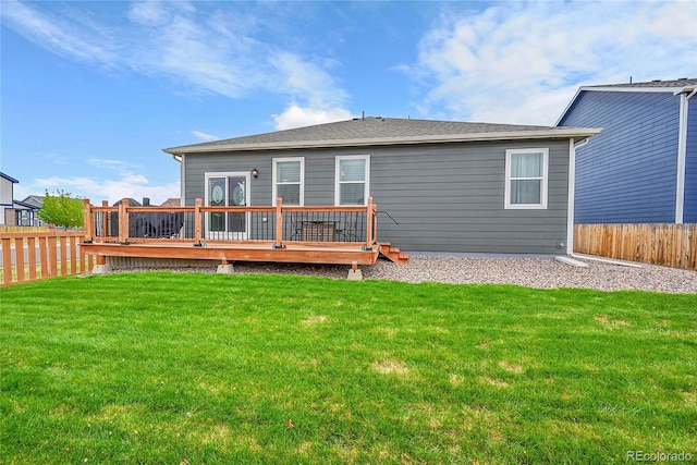 rear view of house featuring fence, a yard, and a wooden deck