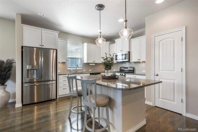 3326 Daydreamer Dr, Colorado Springs, CO 80908 - kitchen featuring appliances with stainless steel finishes, dark wood finished floors, a kitchen island, white cabinets, and recessed lighting