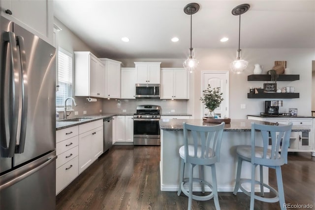 3326 Daydreamer Dr, Colorado Springs, CO 80908 - kitchen featuring stainless steel appliances, dark wood-style floors, white cabinetry, a kitchen island, and recessed lighting