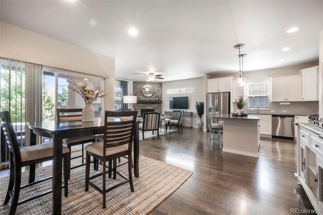 3326 Daydreamer Dr, Colorado Springs, CO 80908 - dining area with a fireplace, a ceiling fan, dark wood-style floors, and recessed lighting