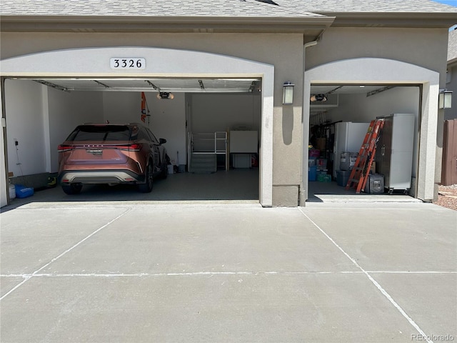 3326 Daydreamer Dr, Colorado Springs, CO 80908 - garage with driveway, a garage door opener, and fridge