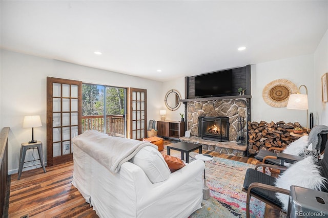11557 Green Cir, Conifer, CO 80433 - living area featuring wood finished floors, a stone fireplace, recessed lighting, and baseboards