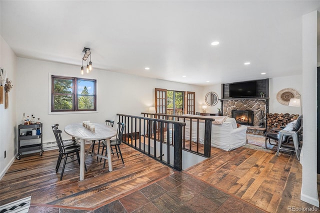 11557 Green Cir, Conifer, CO 80433 - dining area with a stone fireplace, recessed lighting, wood finished floors, and baseboards