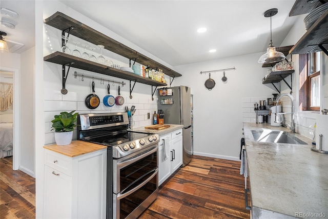 11557 Green Cir, Conifer, CO 80433 - kitchen with stainless steel appliances, open shelves, a sink, decorative backsplash, and dark wood finished floors