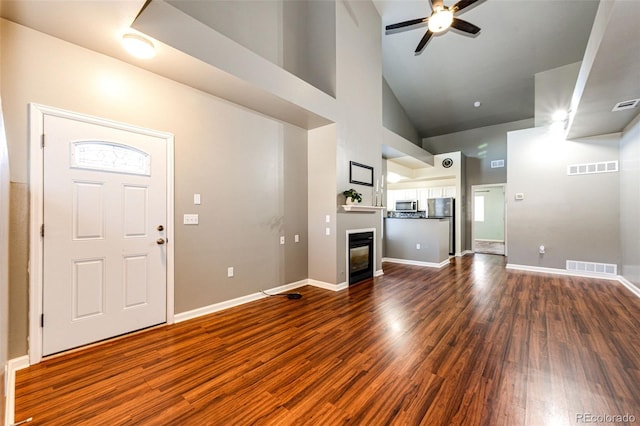 foyer featuring high vaulted ceiling, ceiling fan, and dark wood-type flooring