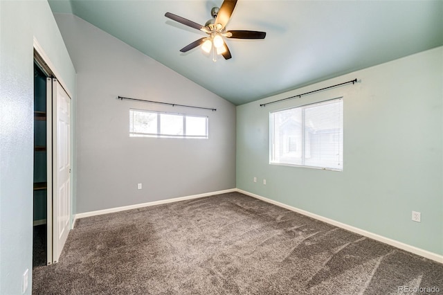 unfurnished bedroom featuring carpet, a closet, vaulted ceiling, and ceiling fan