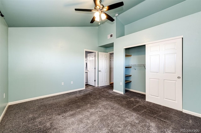 unfurnished bedroom with ceiling fan, dark carpet, high vaulted ceiling, and a closet