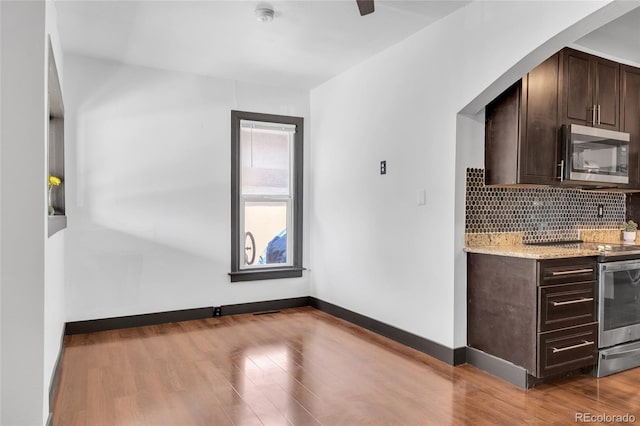 4432 Columbine St, Denver, CO 80216 - kitchen with appliances with stainless steel finishes, dark brown cabinetry, tasteful backsplash, and wood finished floors