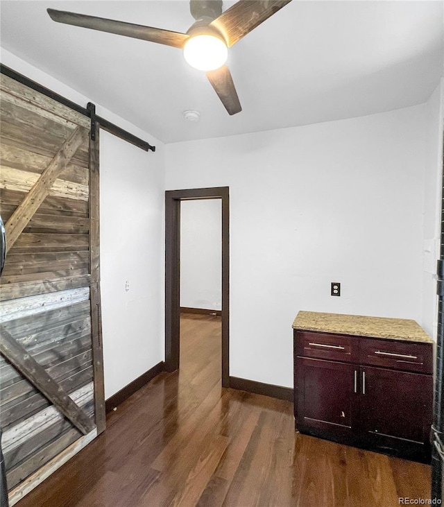 4432 Columbine St, Denver, CO 80216 - unfurnished room featuring dark wood-style flooring, a ceiling fan, a barn door, and a smoke detector